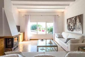 a living room with a white couch and a window at Gorgeous Villa near Ibiza centre in Santa Eularia des Riu