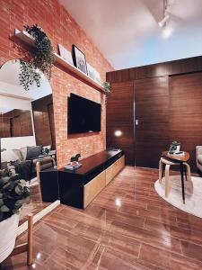 a living room with a brick wall and a tv at Rustic industrial 1-BR condo with balcony at Air Residences Makati Manila in Manila