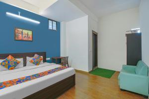 a bedroom with a bed and a blue wall at FabExpress Saket Inn in Bhopal