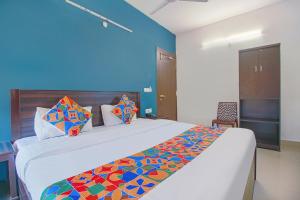 a bedroom with a large bed with a blue wall at FabExpress Saket Inn in Bhopal