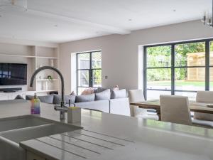 a kitchen and living room with a sink and a table at Pass the Keys Luxury 4 Bedroom home with large garden in Watford