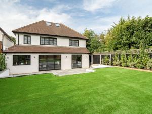 ein Haus mit einem großen Garten mit grünem Gras in der Unterkunft Pass the Keys Luxury 4 Bedroom home with large garden in Watford