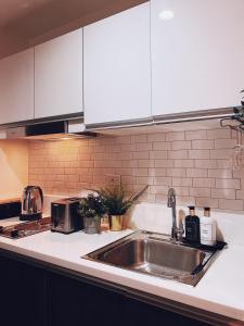 a kitchen with a stainless steel sink and white cabinets at Rustic industrial 1-BR condo with balcony at Air Residences Makati Manila in Manila