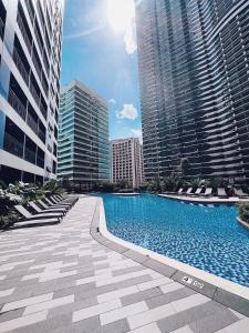 een zwembad in een stad met hoge gebouwen bij Rustic industrial 1-BR condo with balcony at Air Residences Makati Manila in Manilla