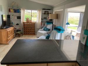 a kitchen and living room with a counter top at Beach Cottage in Kleinmond