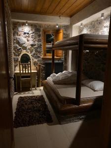a bedroom with a bunk bed and a stone wall at Villa Ardamis Karyes in Karyes
