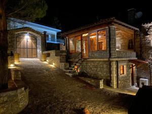 a stone house with a garage at night at Villa Ardamis Karyes in Karyes