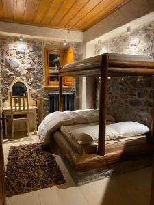 ein Schlafzimmer mit einem Holzbett in einer Steinmauer in der Unterkunft Villa Ardamis Karyes in Karyes
