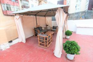 una sombrilla en un patio con sillas y mesa en Room in Guest room - Private room with sunny terrace of 200m2 3, en Barcelona
