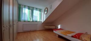 Pokój na poddaszu z łóżkiem i oknem w obiekcie Appartements Donaublick w Linzu