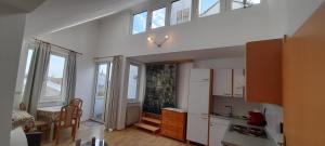 kuchnia z białymi urządzeniami i oknami w pokoju w obiekcie Appartements Donaublick w Linzu
