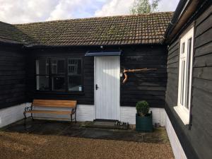 a bench sitting outside of a house with a door at Long Hoyle Annexe in Heyshott