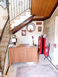 Una escalera en una casa con un escritorio en una habitación en Refúgio das Artes en Porto de Mós