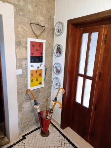 a hallway with an umbrella on the wall next to a door at Refúgio das Artes in Porto de Mós