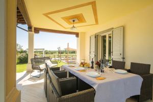 stół z krzesłami i biały blat na patio w obiekcie Casa Romano by VacaVilla w mieście Cortona