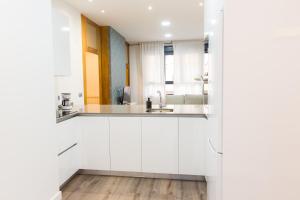 baño con armarios blancos y espejo en Moderno Apartamento LAUD3 - Nuevo/Familiar/Wifi/TV, en Valladolid