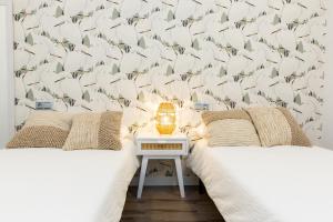 1 dormitorio con 2 camas y una pared de pájaros en Moderno Apartamento LAUD3 - Nuevo/Familiar/Wifi/TV, en Valladolid