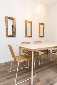 mesa de comedor con sillas y espejos en la pared en Moderno Apartamento LAUD3 - Nuevo/Familiar/Wifi/TV, en Valladolid