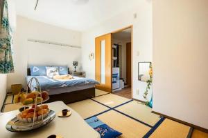東京にある都心の家-ダブルベットと畳み3人部屋のベッド1台、フルーツボウル1杯(テーブル上)が備わります。