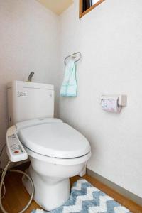 東京にある都心の家-ダブルベットと畳み3人部屋のバスルーム(白いトイレ、青いタオル付)