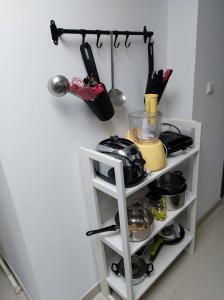 uma prateleira branca com utensílios de cozinha em Chambres privatives avec espaces partagés dans maison Roubaix centre em Roubaix