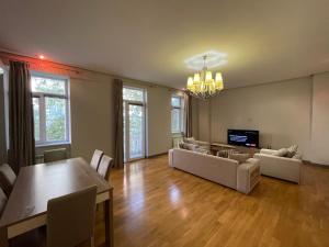 a living room with couches and a dining room at Central Park apartment in Baku