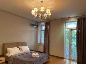 sypialnia z łóżkiem i żyrandolem w obiekcie Central Park apartment w mieście Baku
