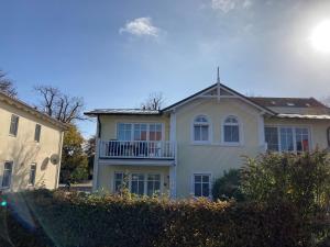 a white house with a balcony on the side of it at Ferienwohnung Andresen in Rerik