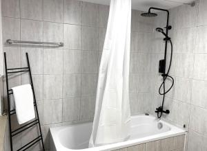 y baño con bañera y cortina de ducha. en City-Apartment No 2, en Reutlingen