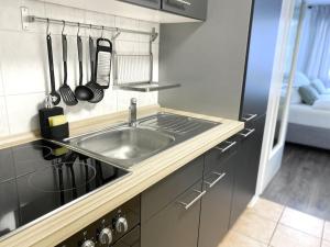 a kitchen with a sink and a counter with utensils at City-Apartment No 2 in Reutlingen