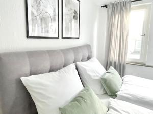 un sofá con almohadas blancas en la sala de estar. en City-Apartment No 2, en Reutlingen