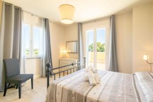 Un dormitorio con una cama y una silla y ventanas. en Casa Romano by VacaVilla, en Cortona