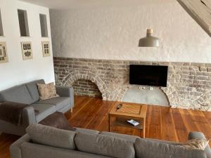 ein Wohnzimmer mit Sofa und Ziegelwand in der Unterkunft Alte Seifensiederei 3 in Stralsund