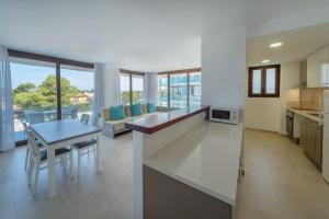 a kitchen and living room with a table and a couch at Aparthotel Caprice Skyline in Ciutadella