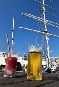 zwei Gläser Bier auf einem Tisch mit einem Schiff in der Unterkunft Alte Seifensiederei 3 in Stralsund