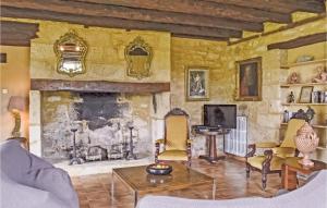 a living room with a stone fireplace and chairs at Nice Home In Domme With Wifi in Domme