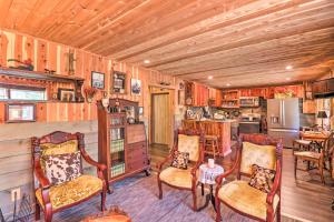 a living room with chairs and a table and a kitchen at Quiet, Historic Manor Located in Ghost Town! in Calico Rock