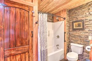 a bathroom with a wooden door and a toilet at Quiet, Historic Manor Located in Ghost Town! in Calico Rock