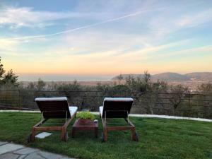 two chairs and a table on a lawn with a view at A CASA DI OLIVO in Castelnuovo Magra