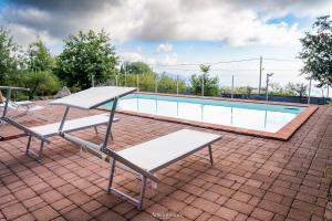 a table and two chairs sitting next to a swimming pool at Tenuta Carbone - Con piscina e parcheggio privato in Mascali