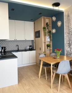 a kitchen with a wooden table and a dining room at FLORA Apartament Słupsk in Słupsk