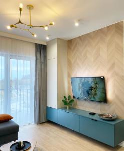 a living room with a blue cabinet and a painting on the wall at FLORA Apartament Słupsk in Słupsk