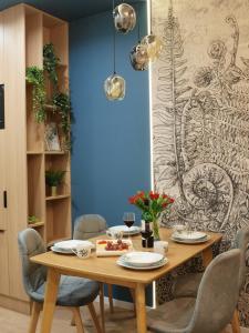 a dining room with a wooden table and chairs at FLORA Apartament Słupsk in Słupsk