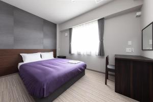 um quarto com uma cama, uma secretária e uma janela em Hotel Classe Stay Chitose em Chitose