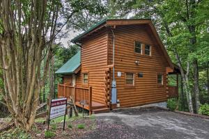 eine Hütte im Wald mit einem Schild davor in der Unterkunft Romantic Pigeon Forge Log Cabin with Hot Tub! in Sevierville