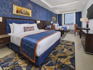 a hotel room with a king sized bed and a desk at Fortune Park, Katra - Member ITC's Hotel Group in Katra