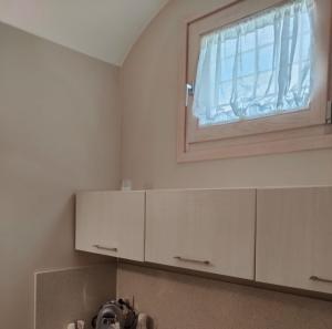 普利亞區格拉維納的住宿－Le Stanze di Finya，厨房配有白色橱柜和窗户。