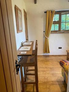una camera con un tavolo in legno con sedie e una finestra di Character 1 bedroom country annex in West Camel a Yeovil