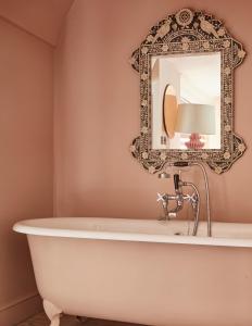 a bathtub in a bathroom with a mirror at The George In Rye in Rye