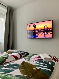 2 camas en una habitación con TV en la pared en Sicomoro Casa en Sopron